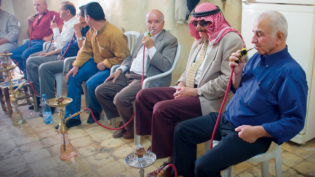 Local Arabs in a Palestinian town gather in a cafe to smoke flavored tobacco in Nargillas